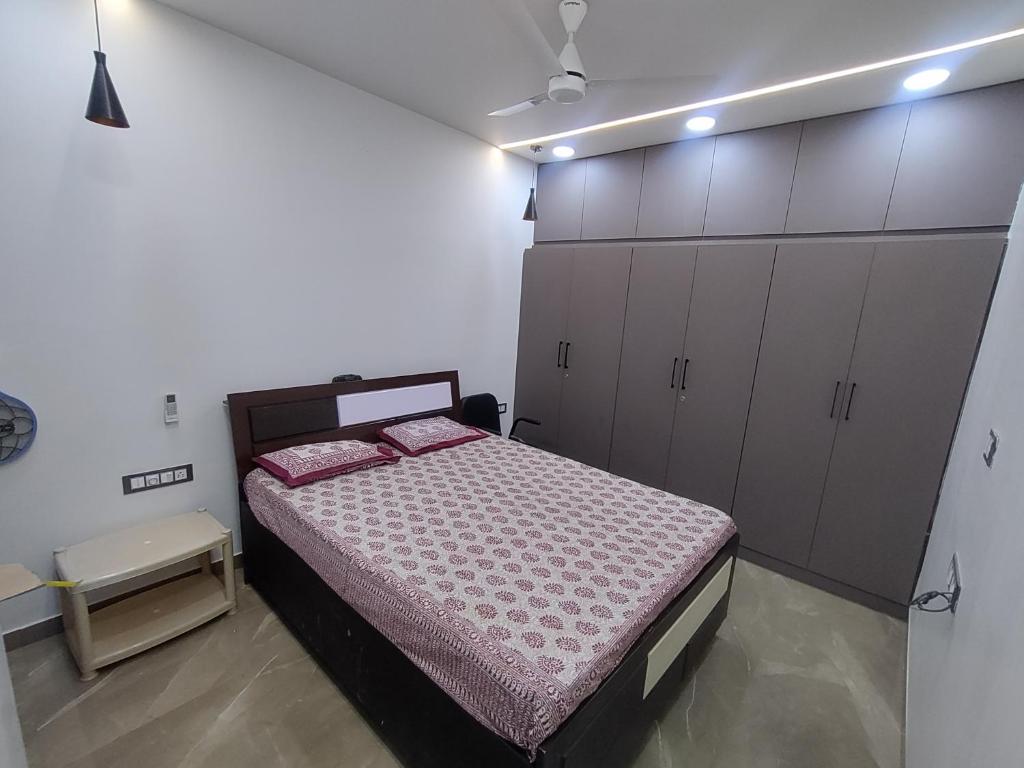 een slaapkamer met een bed en een aantal kasten bij Om Nivas in Bhuj