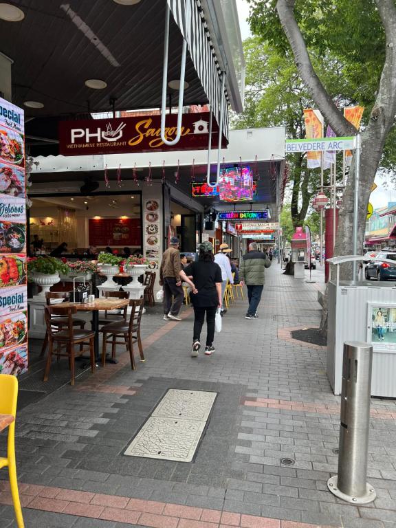 een persoon die over een stoep loopt voor een restaurant bij Alison's central apartment in Cabramatta