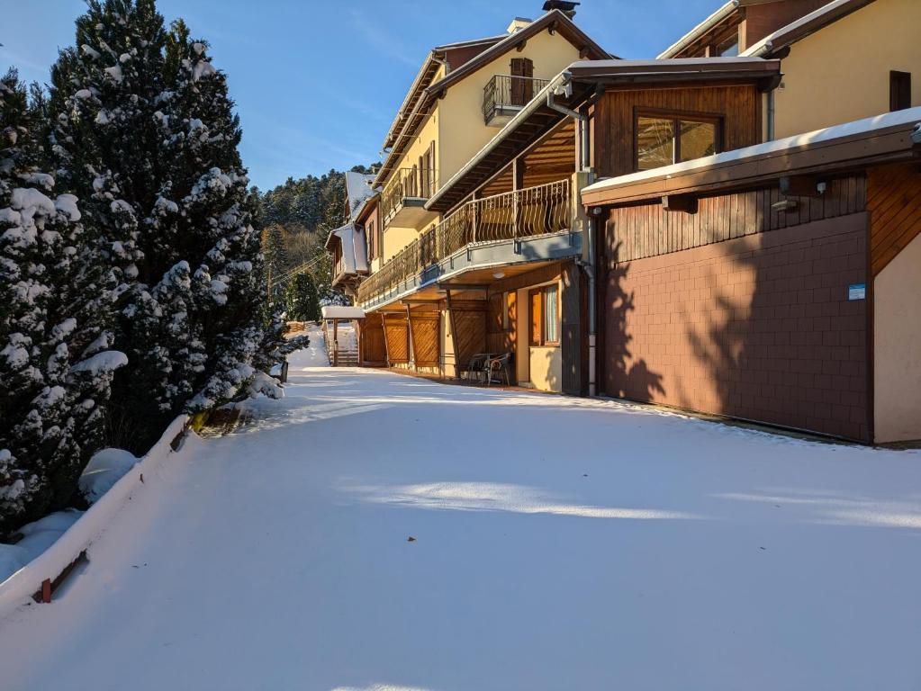 a snow covered street in front of a house at La source in Sondernach