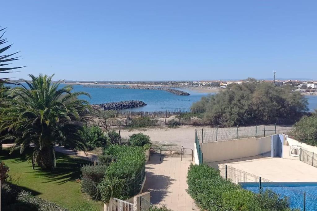 vista su una spiaggia con piscina e acqua di Appartement vue mer a Sète