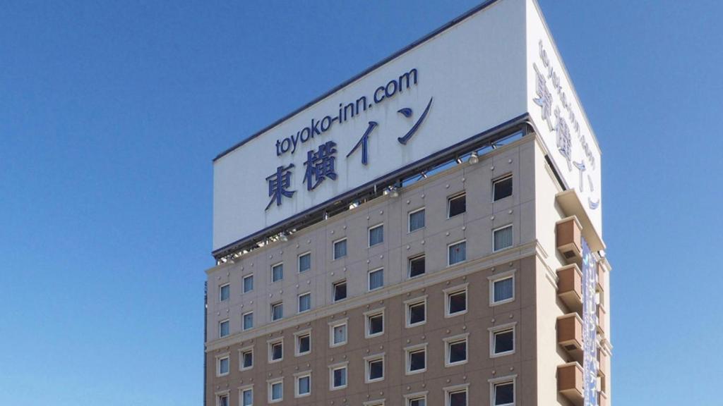 a building with a sign on top of it at Toyoko Inn Kitakami eki Shinkansen guchi in Kitakami