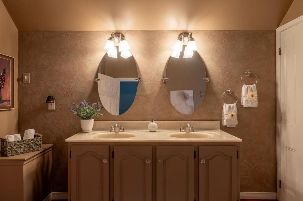 a bathroom with two sinks and two mirrors at Auberge Old Chelsea in Chelsea