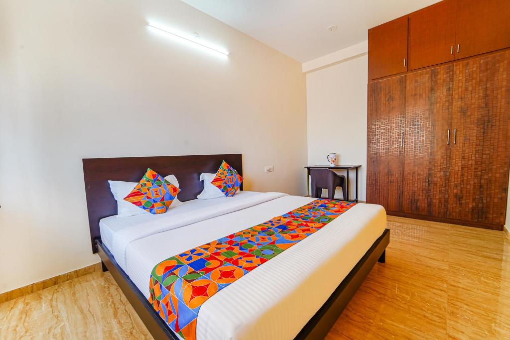 a bedroom with a large bed with a colorful blanket at FabHotel Saro Sri Residency in Coimbatore