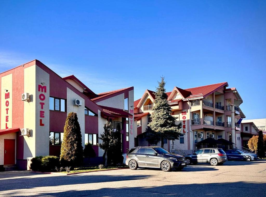 un grupo de coches estacionados frente a un edificio en Hotel Levisticum, en Bacău