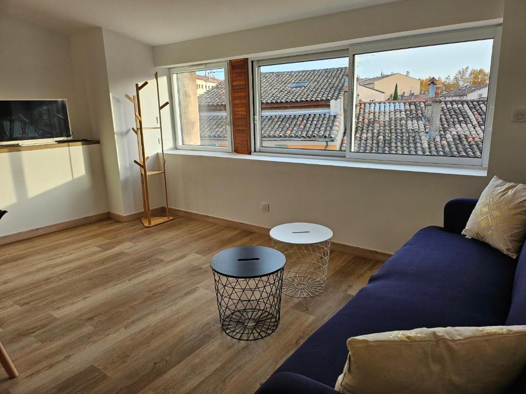 a living room with a couch and a large window at Sur les toits in Draguignan