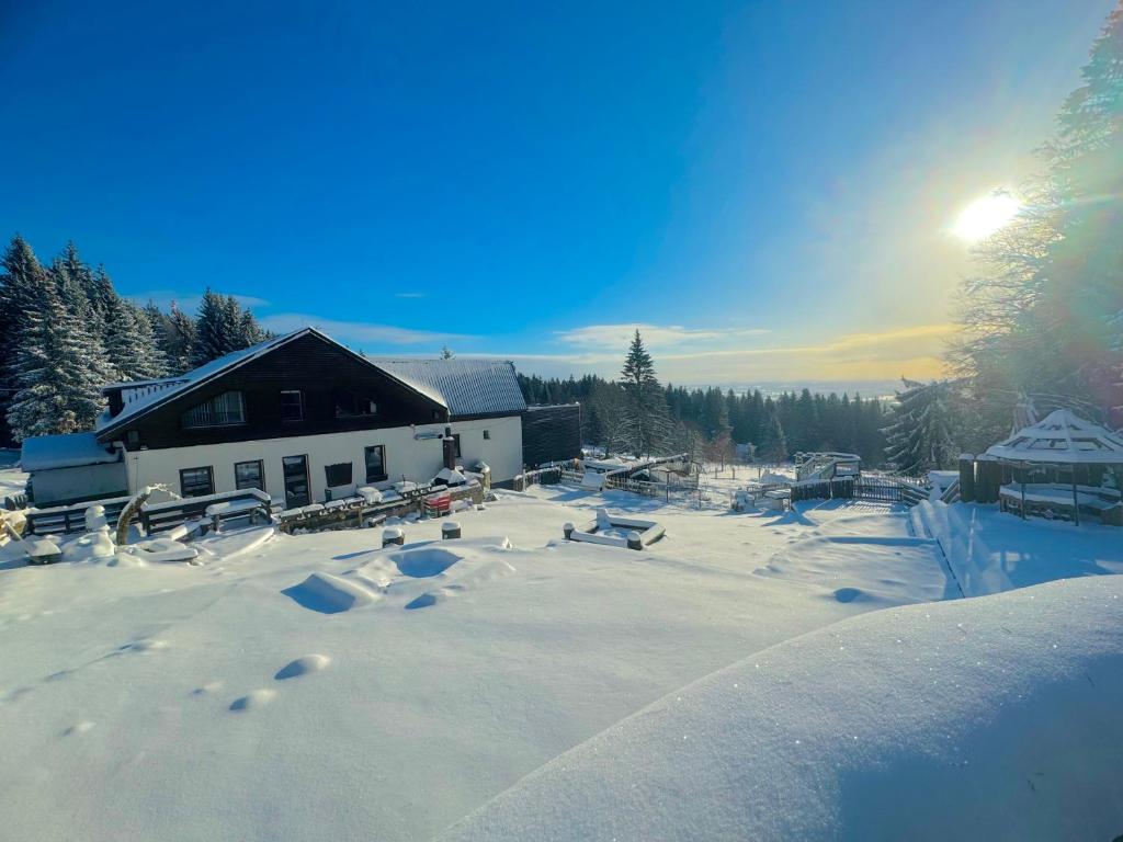 un cortile coperto da neve di fronte a un edificio di Penzion Berany a Jablonec nad Nisou