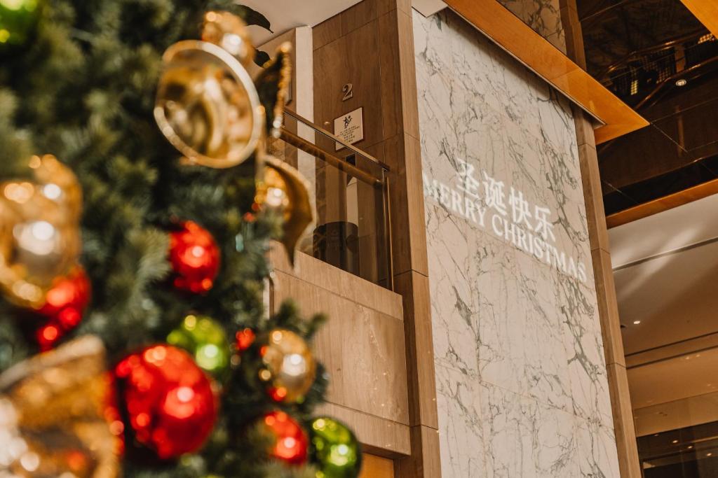 un arbre de Noël devant un mur dans l'établissement Sheraton Guangzhou Hotel, à Canton