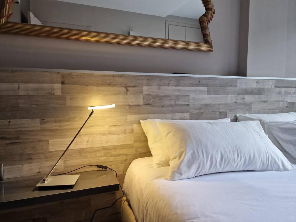 1 dormitorio con cama blanca y cabecero de madera en Elegante 5 estrellas en Grandvalira El Tarter, en Canillo