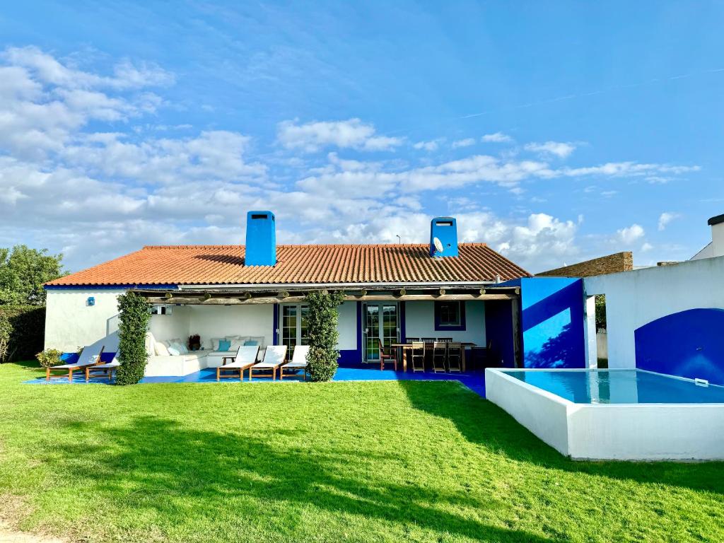 ein Haus mit einem Garten mit Pool in der Unterkunft Comporta - Wood & Blue in Comporta