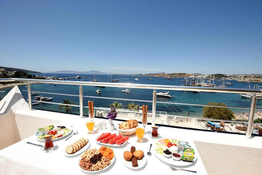 uma mesa com pratos de comida em cima de uma varanda em Mia Hill Suites em Bodrum City