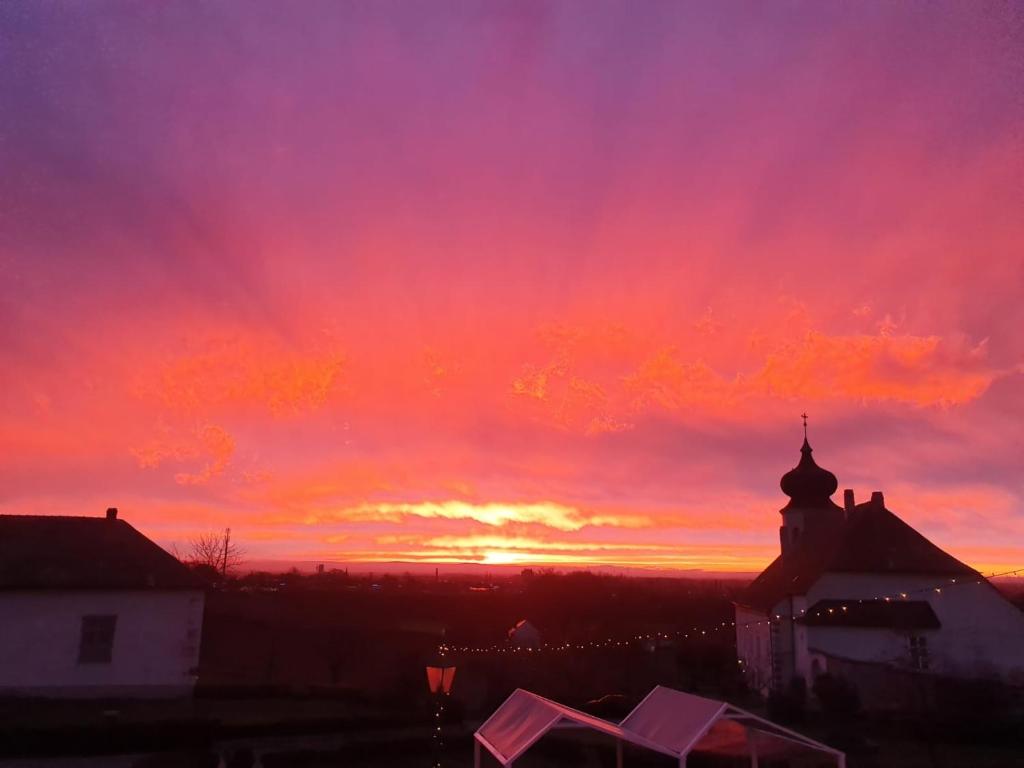 a sunset over a city with a church at Freigut Thallern in Gumpoldskirchen