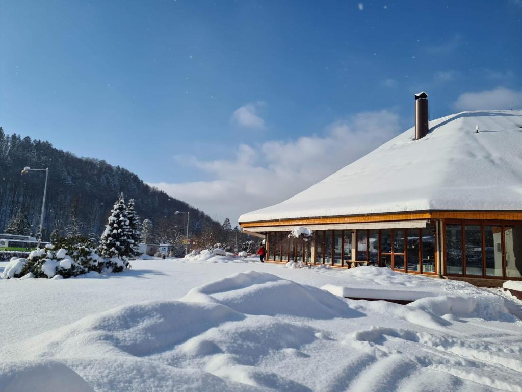 a building covered in snow with a pile of snow at Hotel Horal in Rožnov pod Radhoštěm