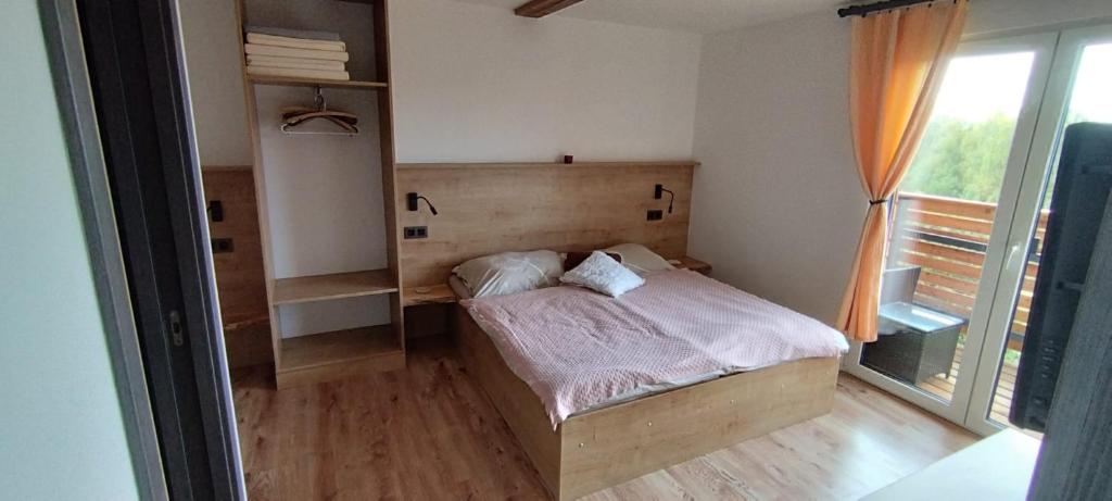 een kleine slaapkamer met een bed en een raam bij Chata POD HOUBOVÝM VRCHEM 2 in Horní Planá