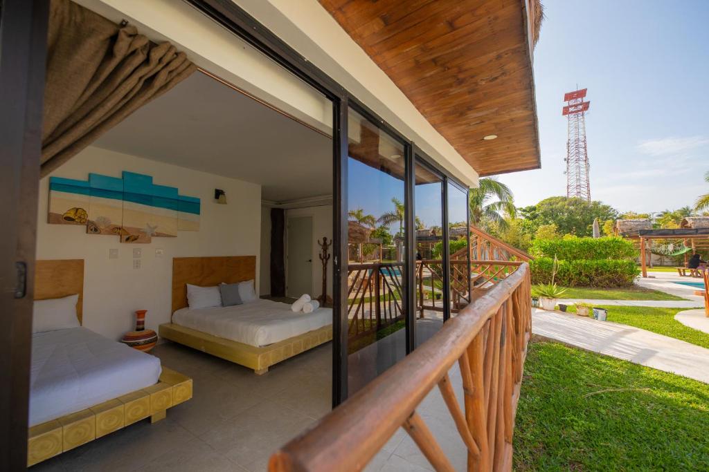 a bedroom with two beds and a balcony at Kabañas Ojo de Agua in Puerto Morelos