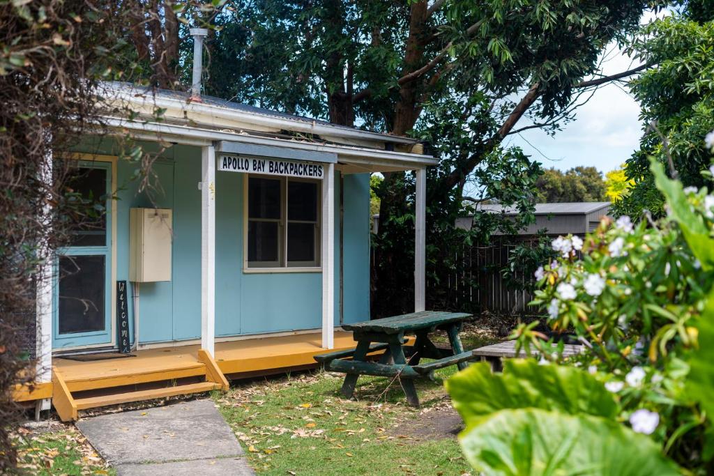 ein kleines blaues Haus mit einem Picknicktisch im Hof in der Unterkunft Apollo Bay Backpackers in Apollo Bay