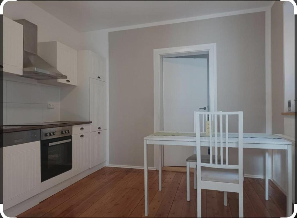 een keuken met een witte tafel en een witte stoel bij Emely Ferienwohnung in Röbel