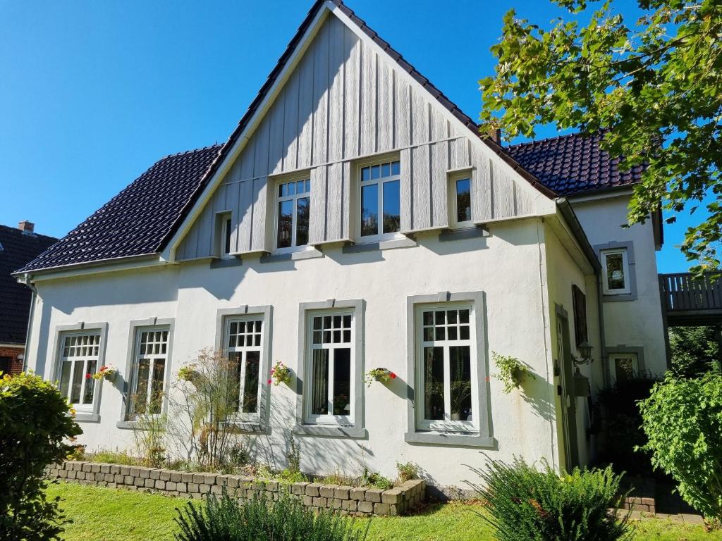 uma casa branca com um telhado de gambrel em Haus Sievertsen Whg1 em Wyk auf Föhr