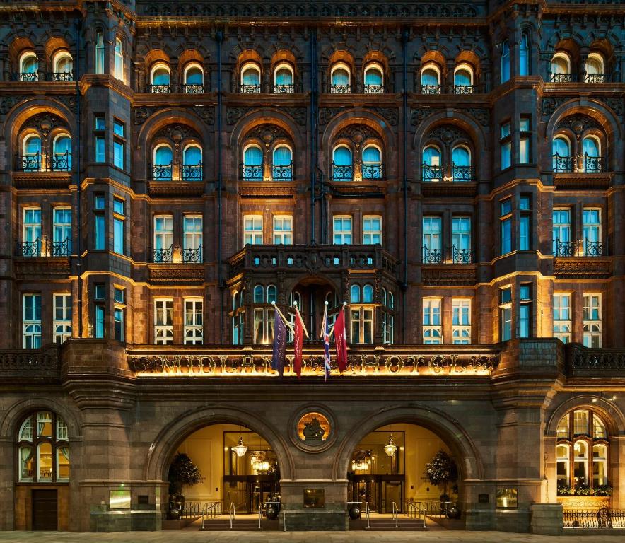 ein großes Gebäude mit zwei Flaggen davor in der Unterkunft The Midland in Manchester