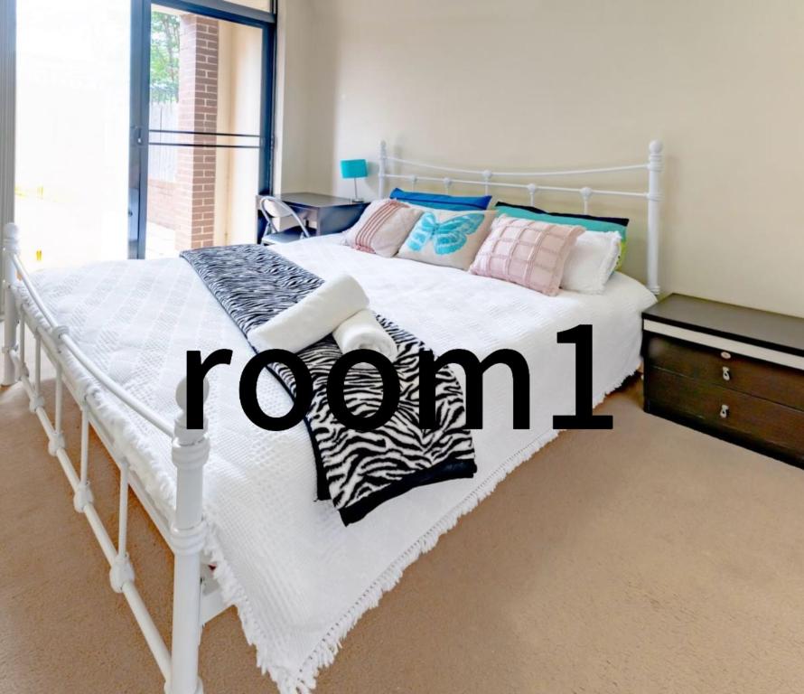 - une chambre avec un lit blanc et un panneau dans l'établissement 3号房源爱旅家园整套, à Baulkham Hills