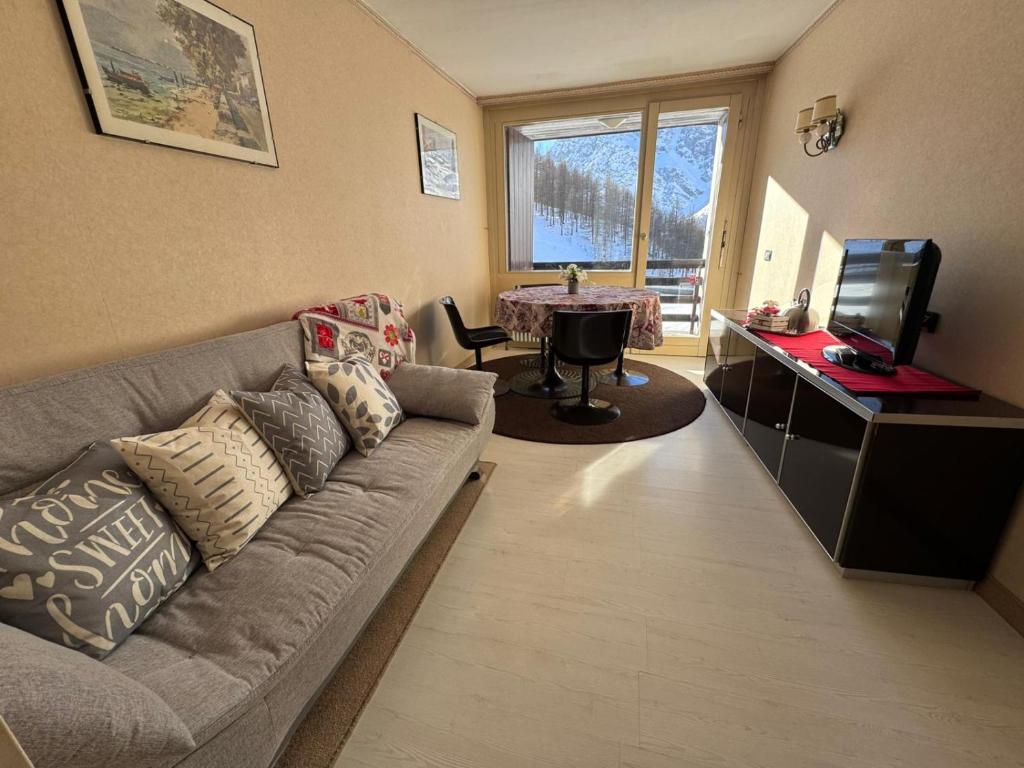 a living room with a couch and a television at Casa Preziosa - Cielo Alto in Breuil-Cervinia