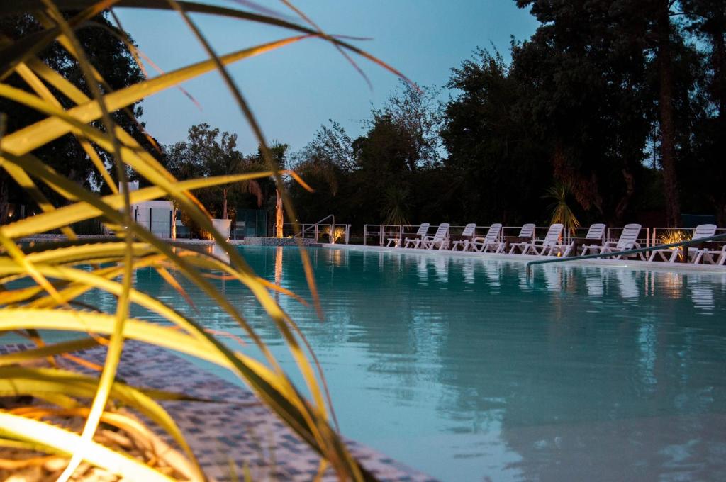 una piscina con sedie a sdraio e acqua di Parque Hotel a Villa Carlos Paz