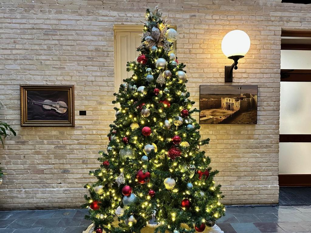 ein Weihnachtsbaum vor einer Ziegelmauer in der Unterkunft The Crockett Hotel in San Antonio