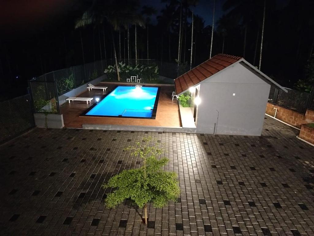 a small swimming pool in a backyard at night at Wild Part in Sultan Bathery