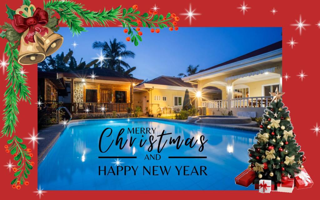 Un árbol de Navidad junto a una piscina con Feliz Navidad y feliz año nuevo en Alona Austria Resort en Panglao City