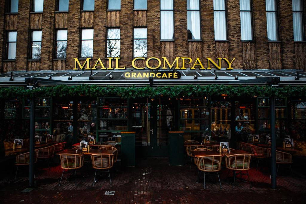 un restaurante con mesas y sillas frente a un edificio en Monument Hotel, en Zaandam