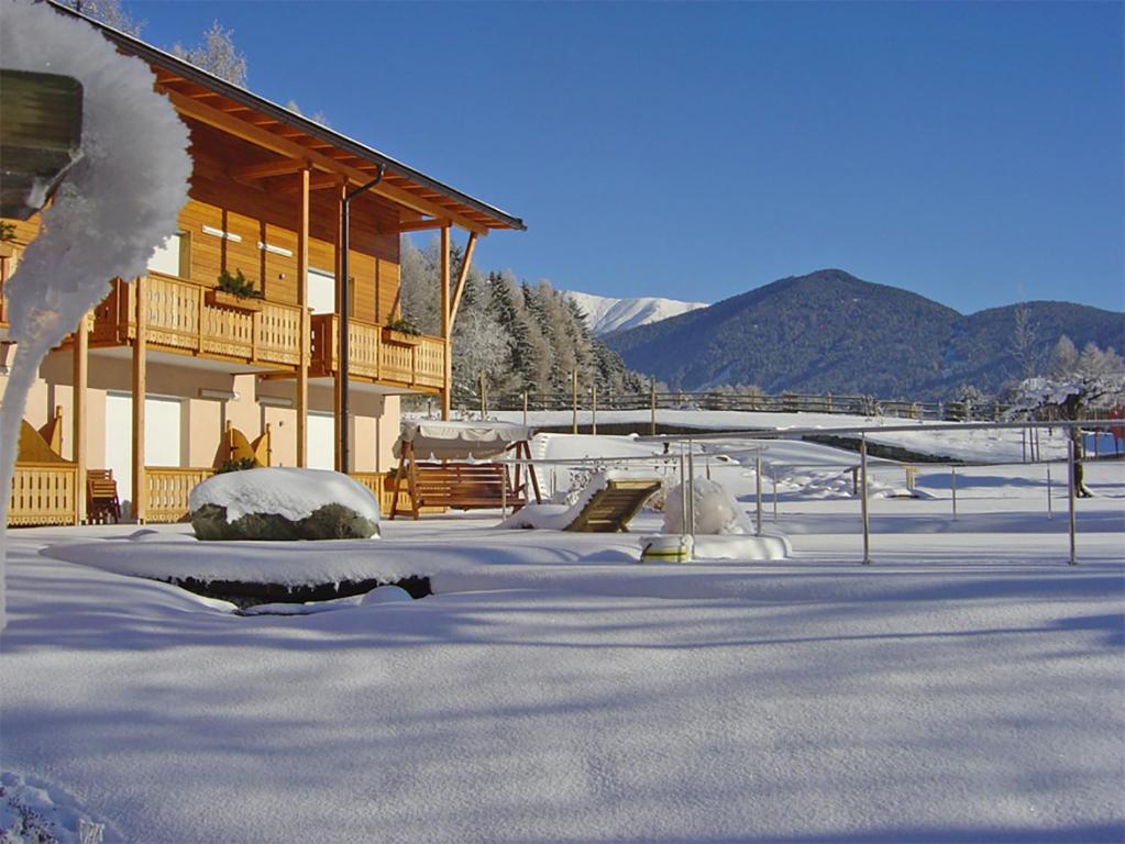 un edificio con nieve en el suelo delante de él en Hotel Gratschwirt, en Dobbiaco