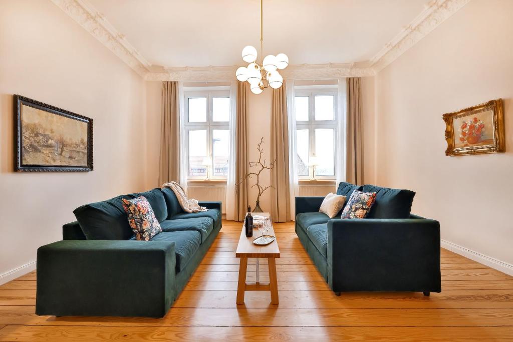 a living room with two blue couches and a table at Apartmenthaus Tribseer Damm 6 in Stralsund