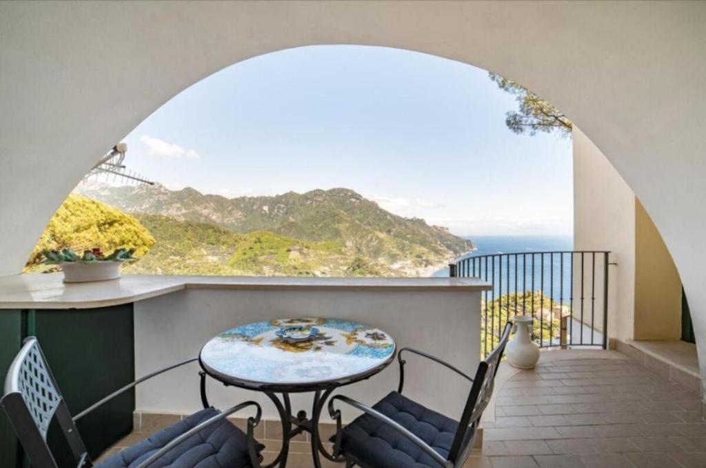 d'un balcon avec une table et des chaises donnant sur l'océan. dans l'établissement La Dolce Vita Ravello - Apartment with Balcony & Amazing View of the Amalfi Coast, à Ravello