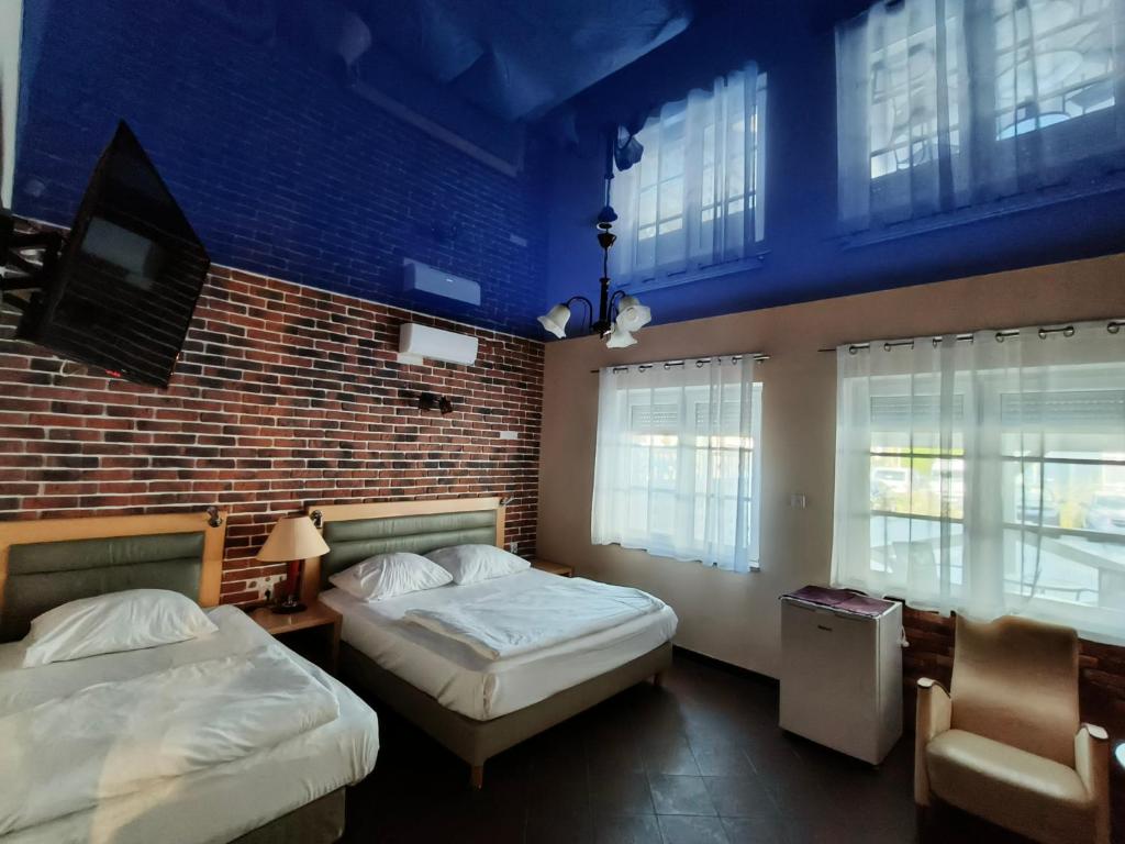 a bedroom with two beds and a brick wall at Villa Bella Casa in Łomianki