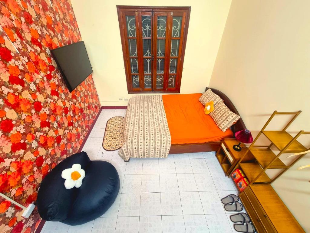 - une petite chambre avec un lit orange et une chaise dans l'établissement LushStay Private Room - Hanoi Train Street, à Hanoï