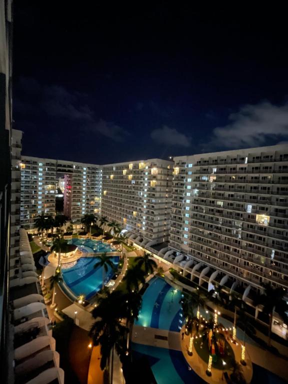 un grande hotel con due piscine di notte di Shell Residences front of SM Mall of Asia 1150 a Manila