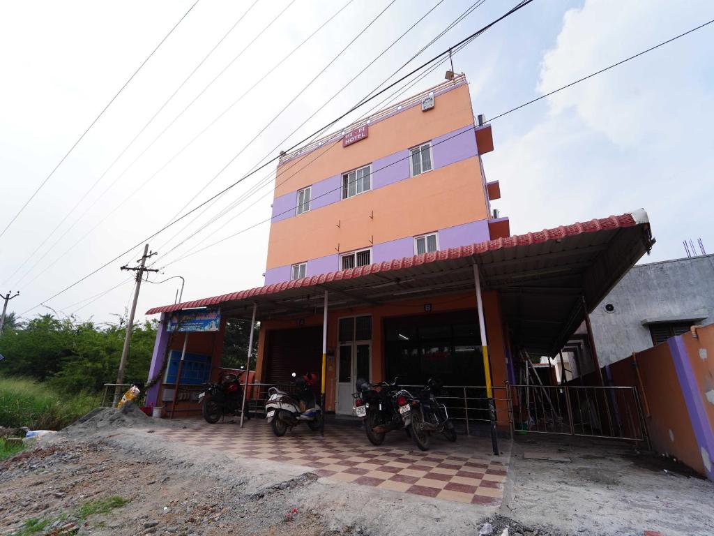 een gebouw met motoren die ervoor geparkeerd staan bij Hotel O Viswapuram in Pīlamedu