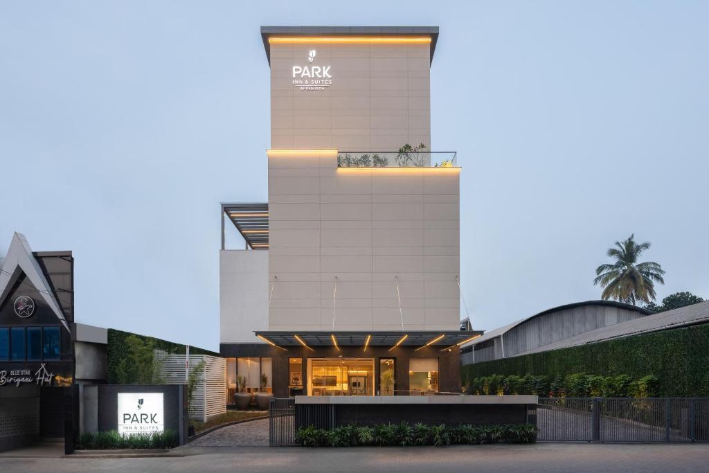 um grande edifício branco com um cartaz em Park Inn & Suites by Radisson Thrissur East Fort em Thrissur