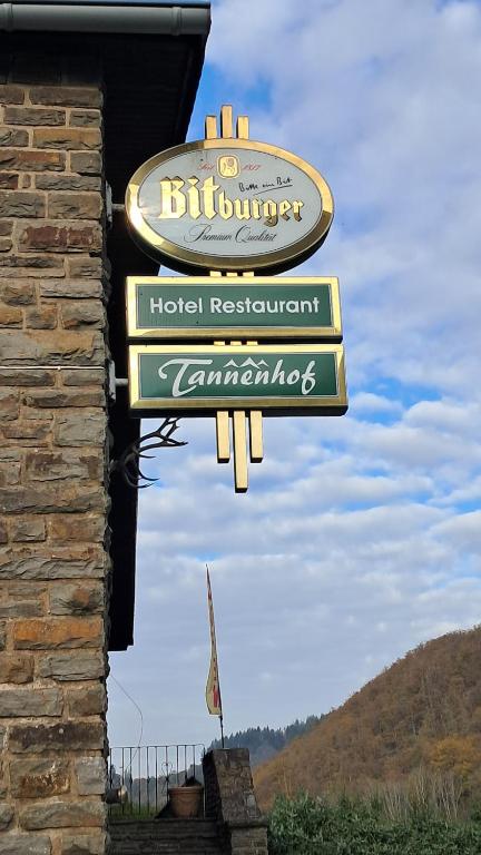 um sinal para um restaurante de hotel num edifício em Hotel-Restaurant Tannenhof em Ahrbrück