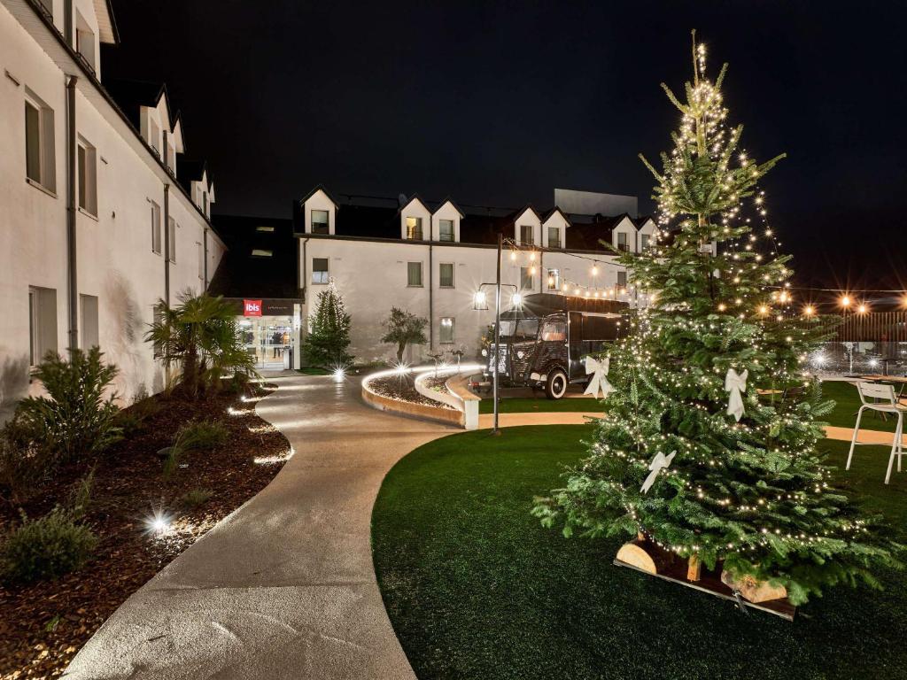 un arbre de Noël dans une cour à côté d'un bâtiment dans l'établissement ibis La Roche Sur Yon Vendespace, à Mouilleron-le-Captif