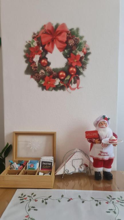 einen Weihnachtskranz an einer Wand mit einer Santa-Klausel auf einem Tisch in der Unterkunft Apartman Zlatovo Stan Na Dan in Požarevac