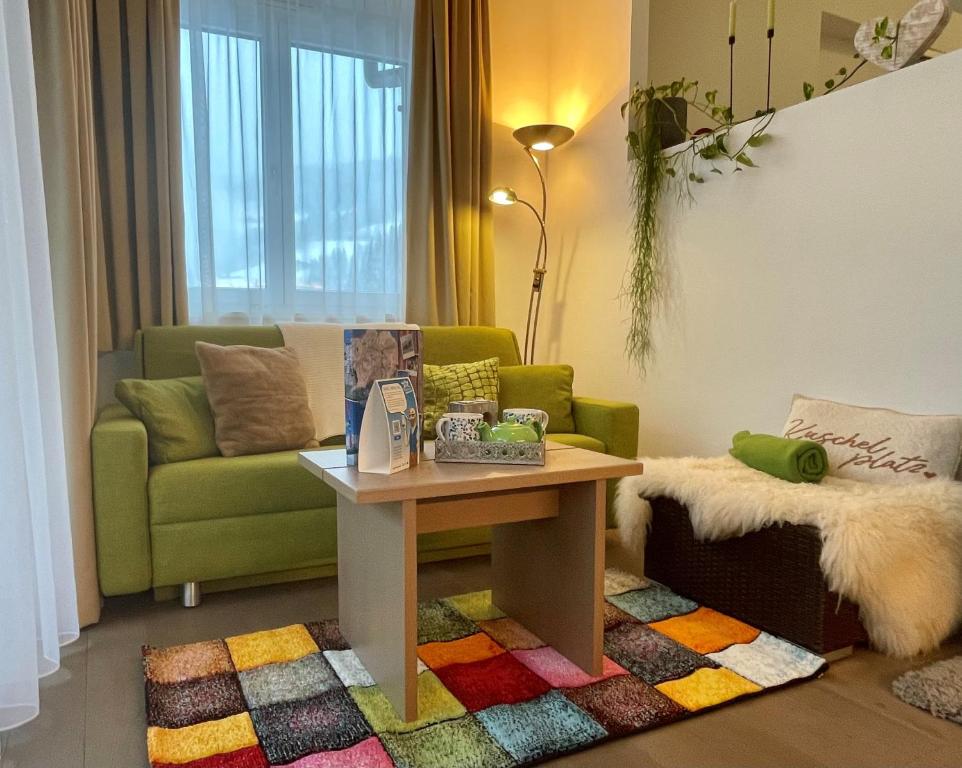 uma sala de estar com um sofá verde e uma mesa em Aparthotel Bergtraum em Mühlbach am Hochkönig