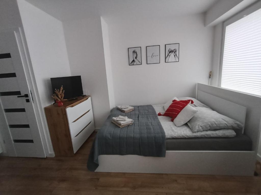 ein kleines Schlafzimmer mit einem Bett und einer Kommode in der Unterkunft Apartament in Ostrołęka