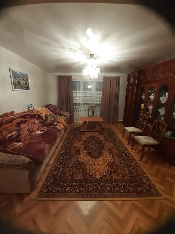 1 dormitorio con cama, mesa y alfombra en Квартира в Коломиї, en Kolomyia