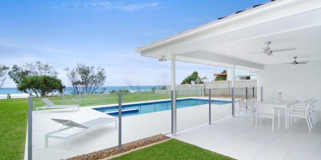 una casa bianca con piscina e patio di Sentosa on Tugun - Beachfront 5 Bedroom a Gold Coast