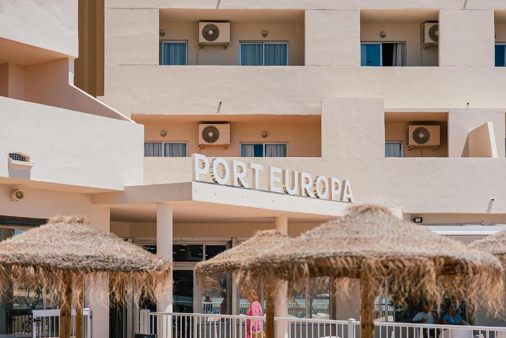 un hotel con ombrelloni di paglia di fronte di Port Europa a Calpe