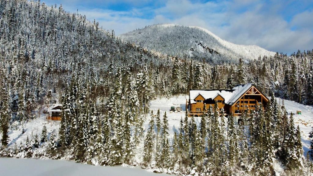 ein Blockhaus im Schnee auf einem Berg in der Unterkunft Auberge Boréale de Charlevoix in Petit-Saguenay