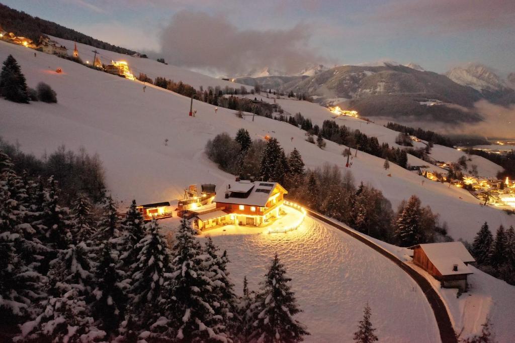 una casa su una pista da sci nella neve di notte di Residenz Erschbaum a Valdaora