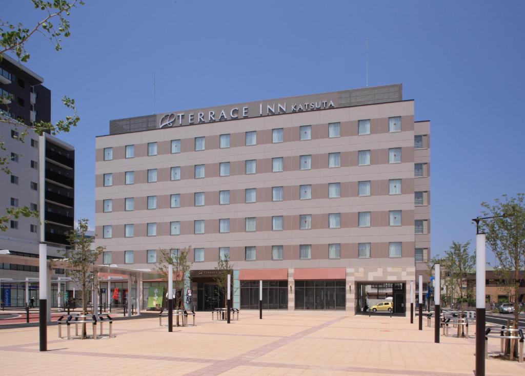 un grand bâtiment avec un panneau à l'avant dans l'établissement Terrace Inn Katsuta, à Hitachinaka