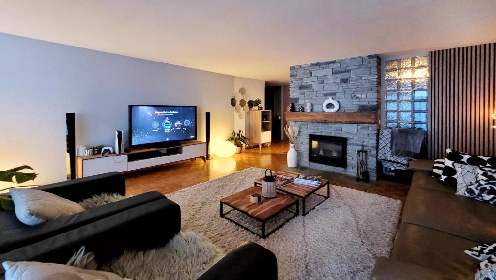 a living room with a couch and a fireplace at L'AvantGardiste, Spacious 6 bedroom panoramic view in Crans-Montana