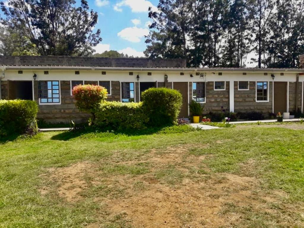 an old house with a yard in front of it at Simply stylish Gardens Naivasha in Naivasha